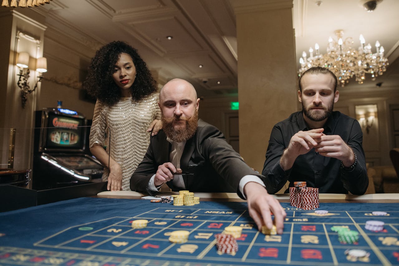 Group of adults playing roulette in a lavish casino setting, showcasing elegance and thrill.